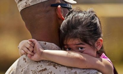 A U.S. Navy officer holds his 3-year-old daughter before deployment: A new study finds that children of military parents are at risk for violent behavior in middle and high school.