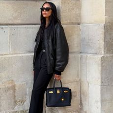 An image of Jasmine Tookes carrying the most designer bags of all time.