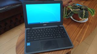 A photo of a Chromebook on a wooden table with its screen on