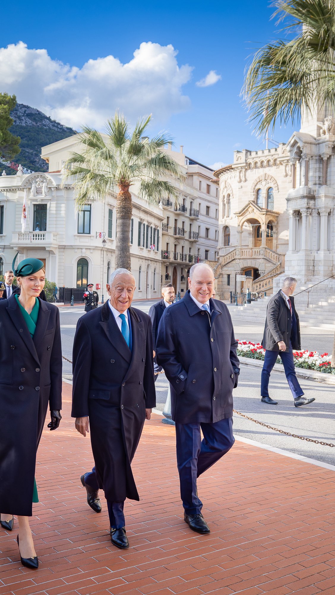 Princess Charlene walking next to the president of Portugal and Prince Albert in front of the palace in Monaco
