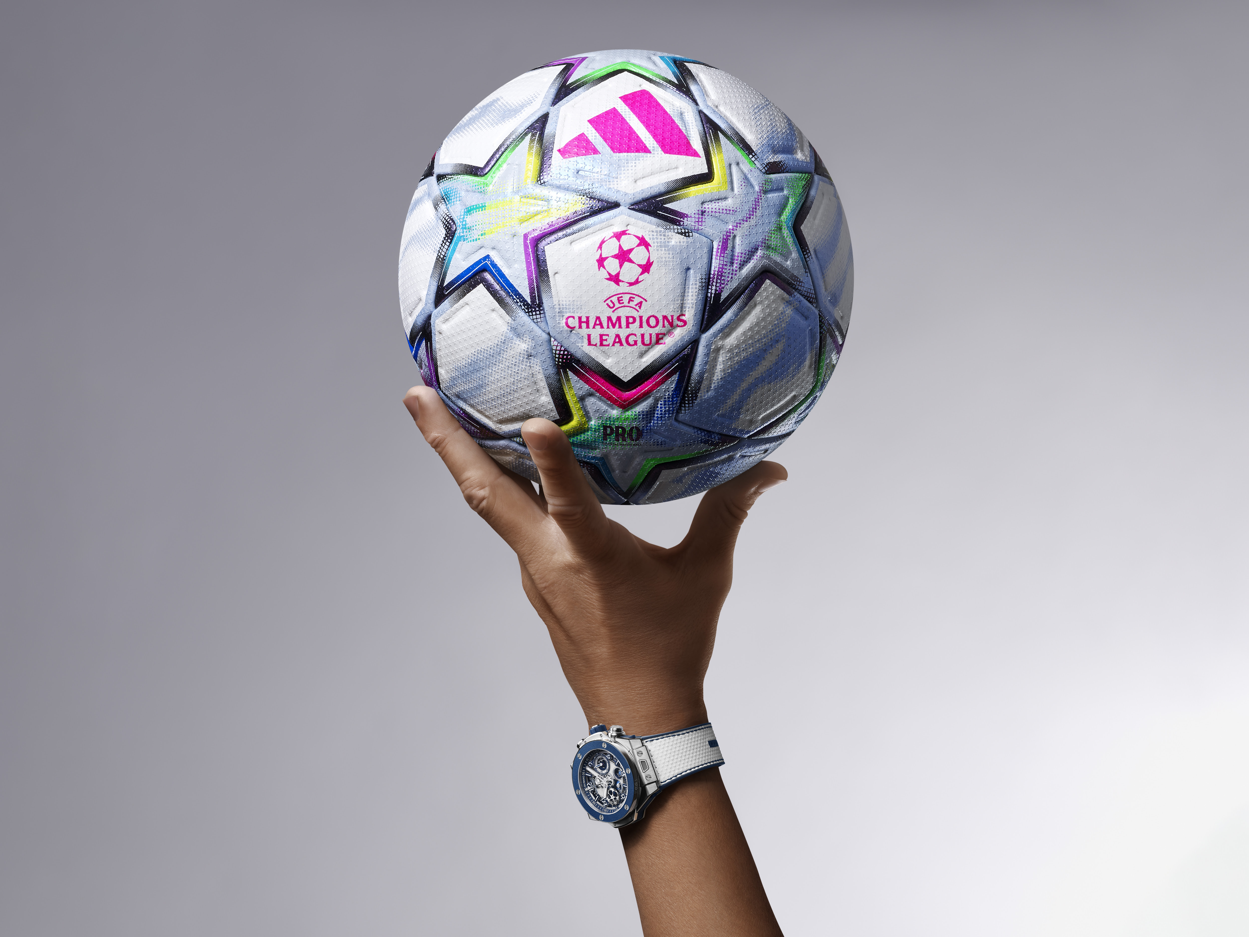 White ceramic watch on a hand holding up a football