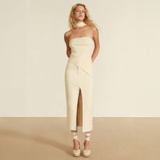 Model wearing a cream midi dress sold at Stradivarius