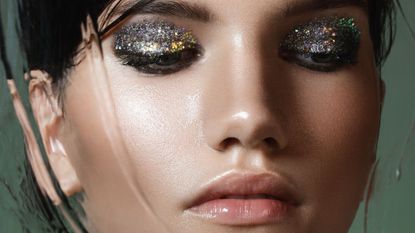 glitter eyeshadow - model with eyes closed and silver eyeshadow - gettyimages 667268691