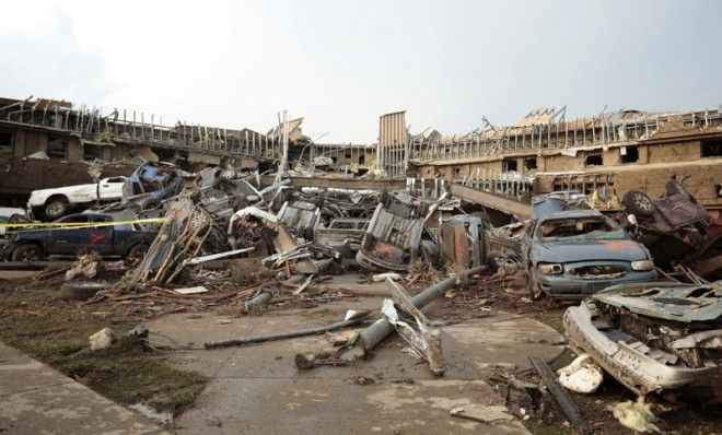 Cars marked with an orange &amp;#039;X&amp;#039;, denoting they had been checked for occupants, are piled up in what was the front entrance to the damaged Moore Medical Center. 