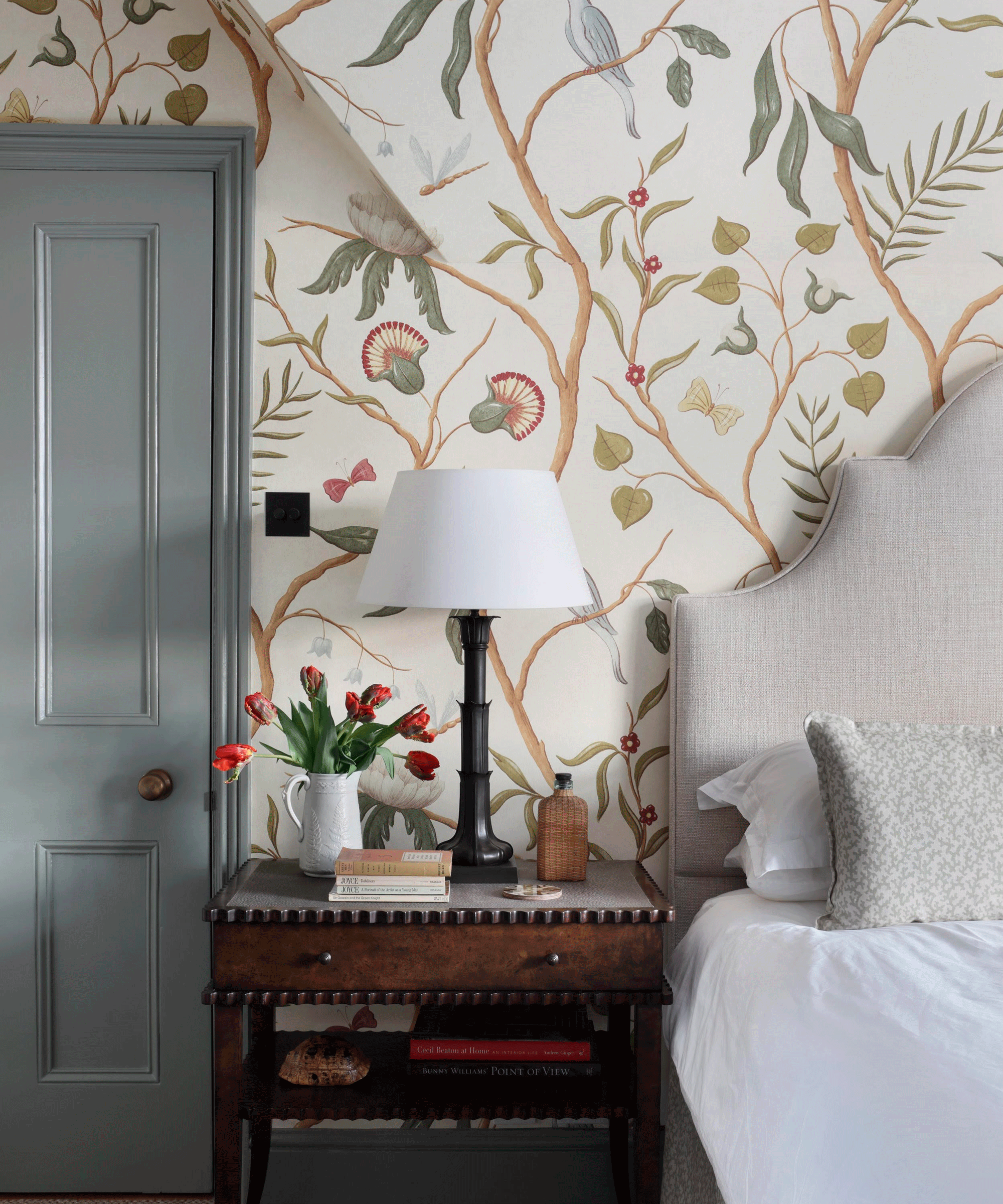 Small bedroom with a mural like wallpaper with tree branches