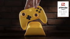 8BitDo Ultimate 2 controller in yellow being placed in its charging cradle