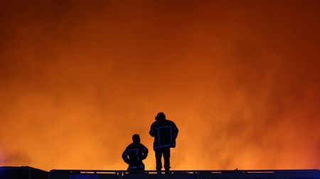 TOPSHOT - Firefighters monitor a wildfire in Le Porge, south-western France on July 22, 2026. A fast-moving wildfire has burned 900 hectares north of Arcachon Bay in southwestern France, forcing the evacuation of more than 4,000 residents and tourists. The blaze, described by firefighters as exceptionally intense, spread sixfold in less than three hours through dense pine forests and is now advancing toward Ares and Lege-Cap-Ferret. The area was previously devastated by major wildfires in 2022. (Photo by ROMAIN PERROCHEAU / AFP via Getty Images)