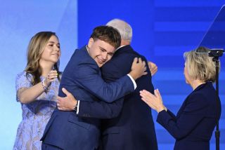 Minnesota Governor and Democratic vice presidential candidate Tim Walz is embraced by his son Gus.