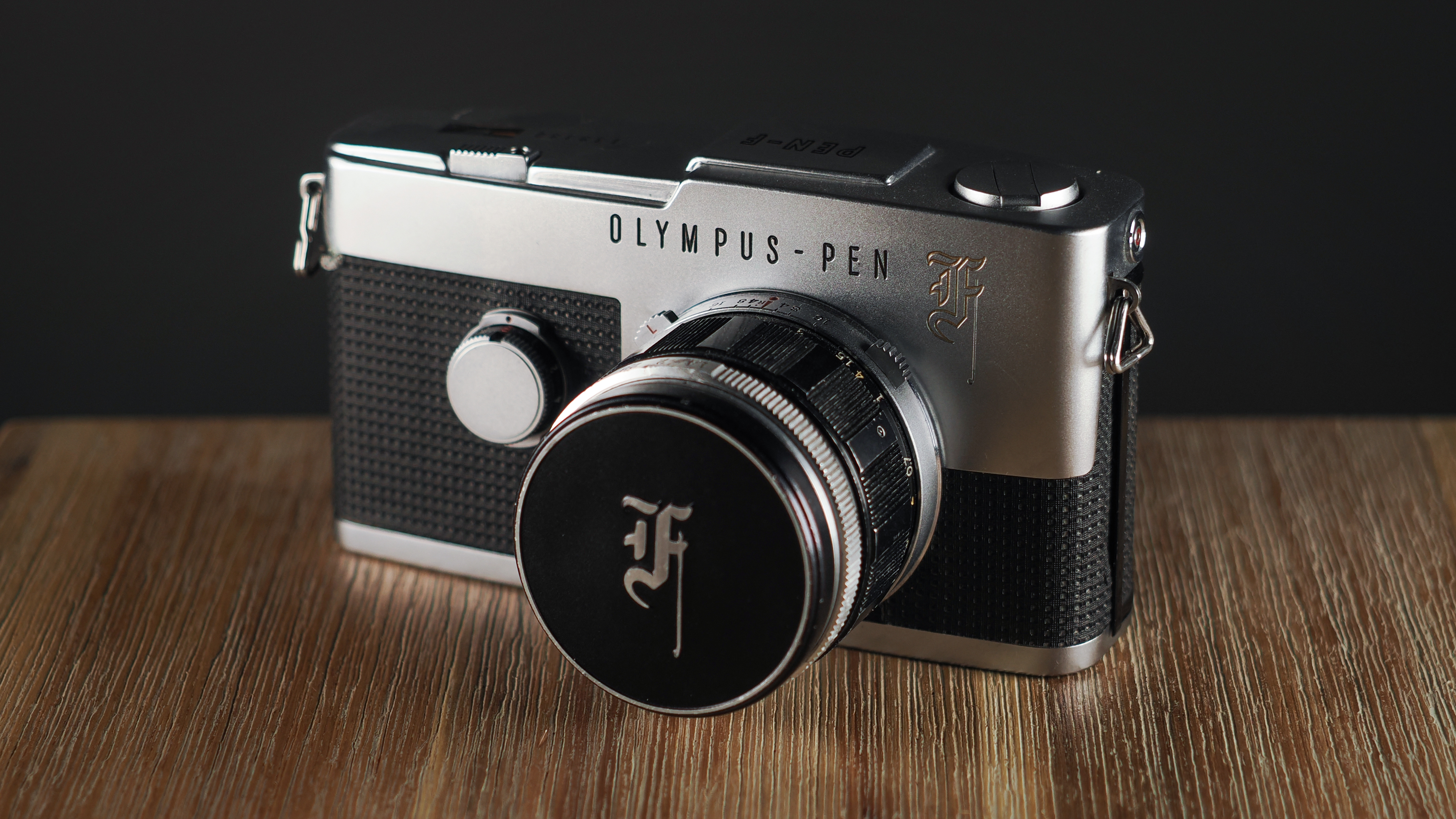 Olympus PEN-F (analog) on a wooden surface