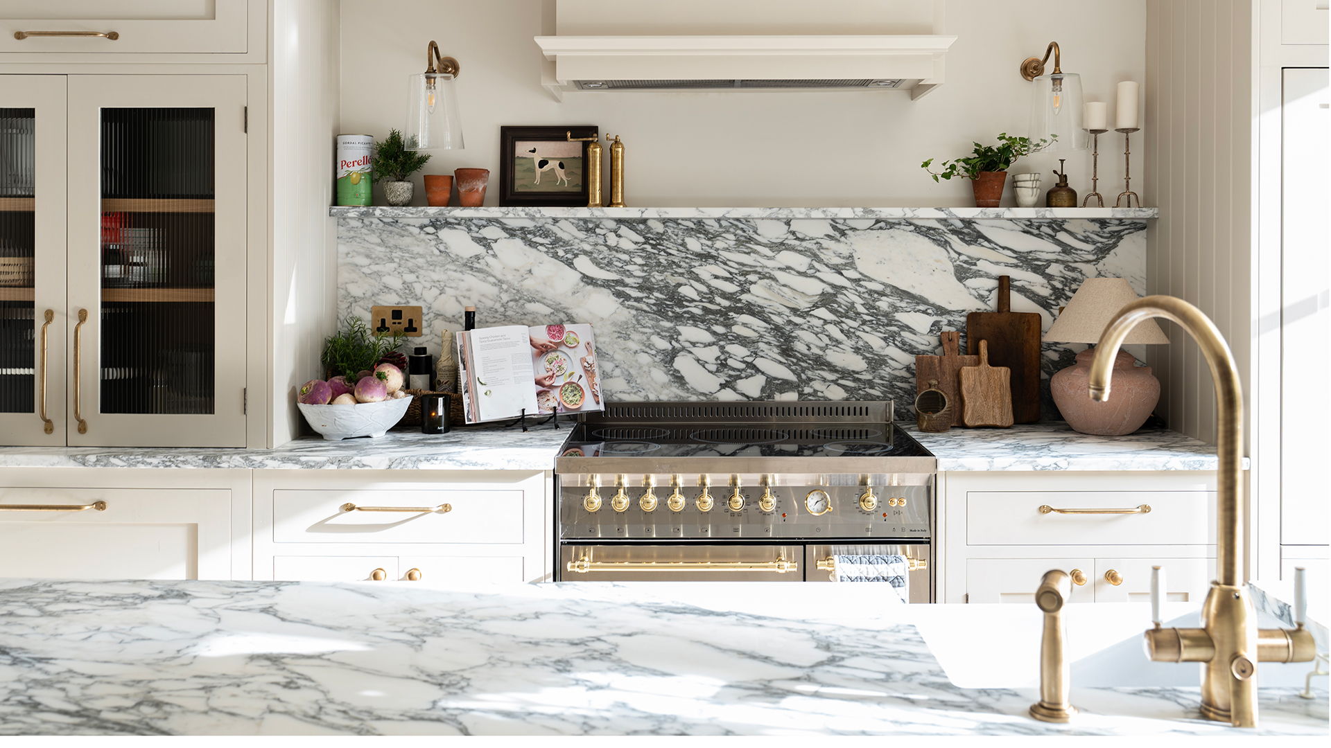 Cream kitchen with a statement black veined marble countertop and splashback