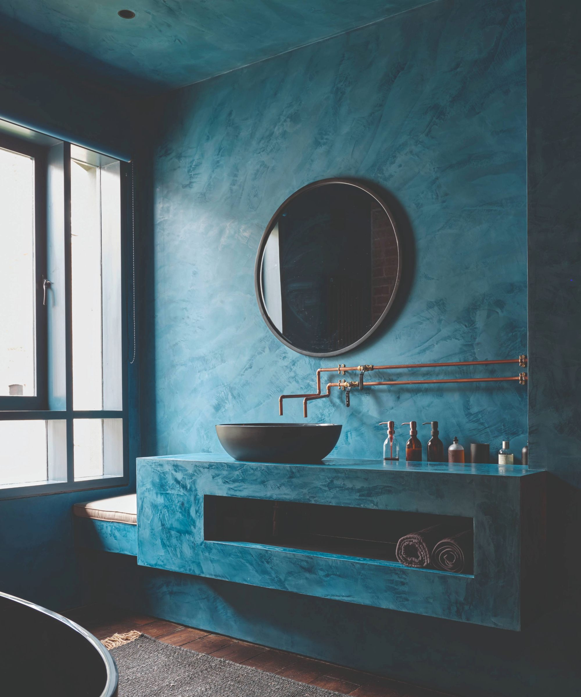 Dark bathroom idea with blue microcement on the walls, vanity worktop and ceiling