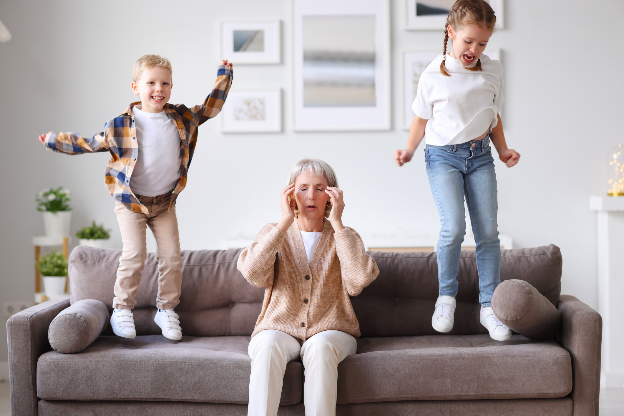 Grandmother with grandchildren jumping on the couch