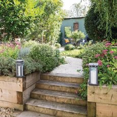 Steps up between the raised beds to the gravel path leading through the garden to the seating area at the end of the garden. 