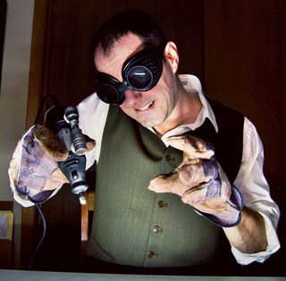 Photo of man wearing a waistcoat and goggles drilling