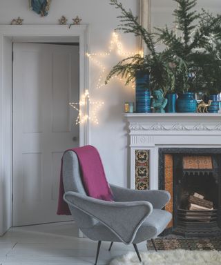 Clean upholstered and cushioned seat in a white room with festive fireplace and light up stars on the wall