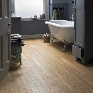 bathroom with wooden flooring white door and white bathtub