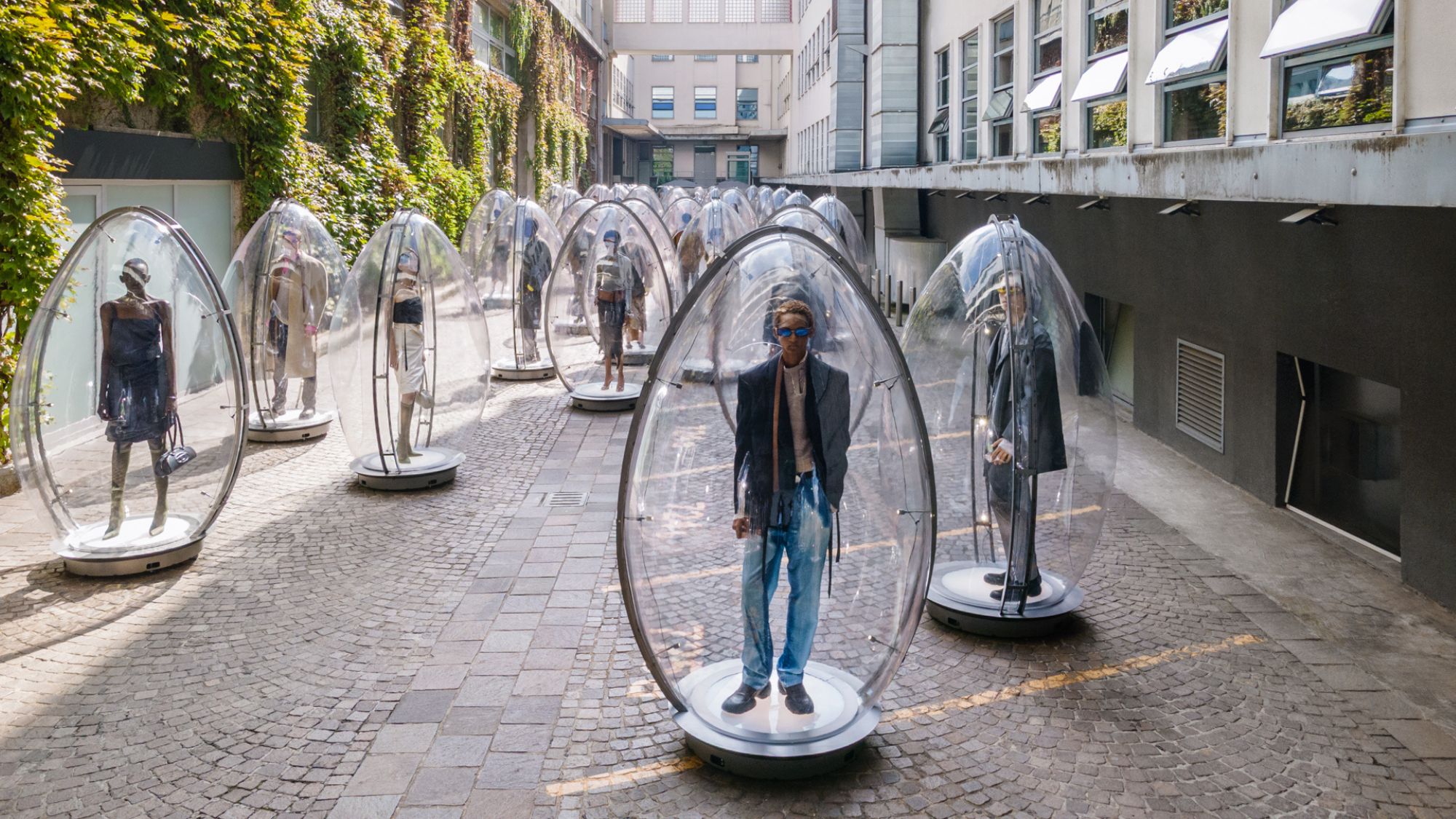 models in perspex eggs for diesel&#039;s ss26 presentation during milan fashion week