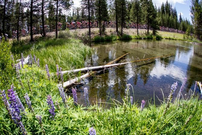 The peloton passes by crystal clear waters along todays route of the Cascade Cycling Classic.