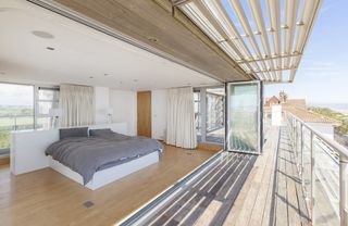 Balcony with white wall and bed