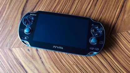 PlayStation Vita handheld on wooden table