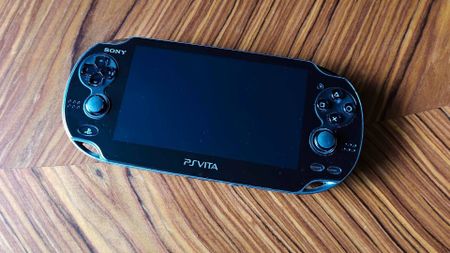 PlayStation Vita handheld on wooden table