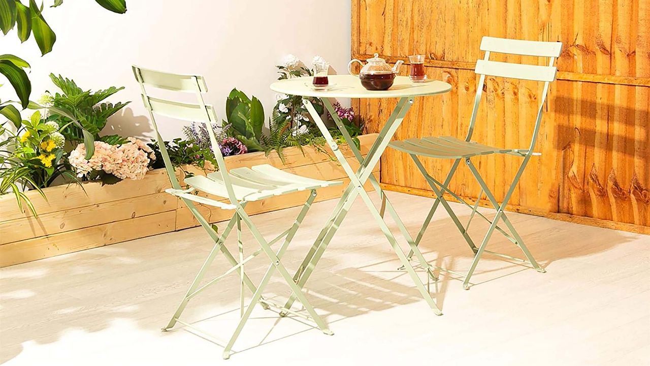 Sage green bistro table and chairs in garden.