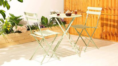 Sage green bistro table and chairs in garden
