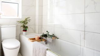 Light bathroom with large format tiles around bath