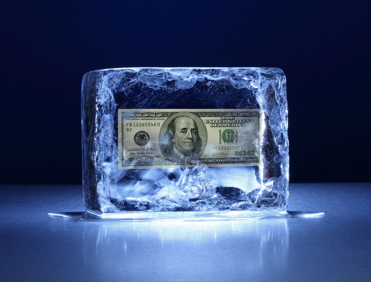 one hundred dollar bill in a block of ice