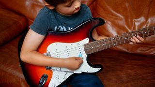 Kid playing an electric guitar