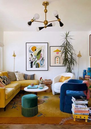 living room with white walls, yellow sofa, blue accent chair and art