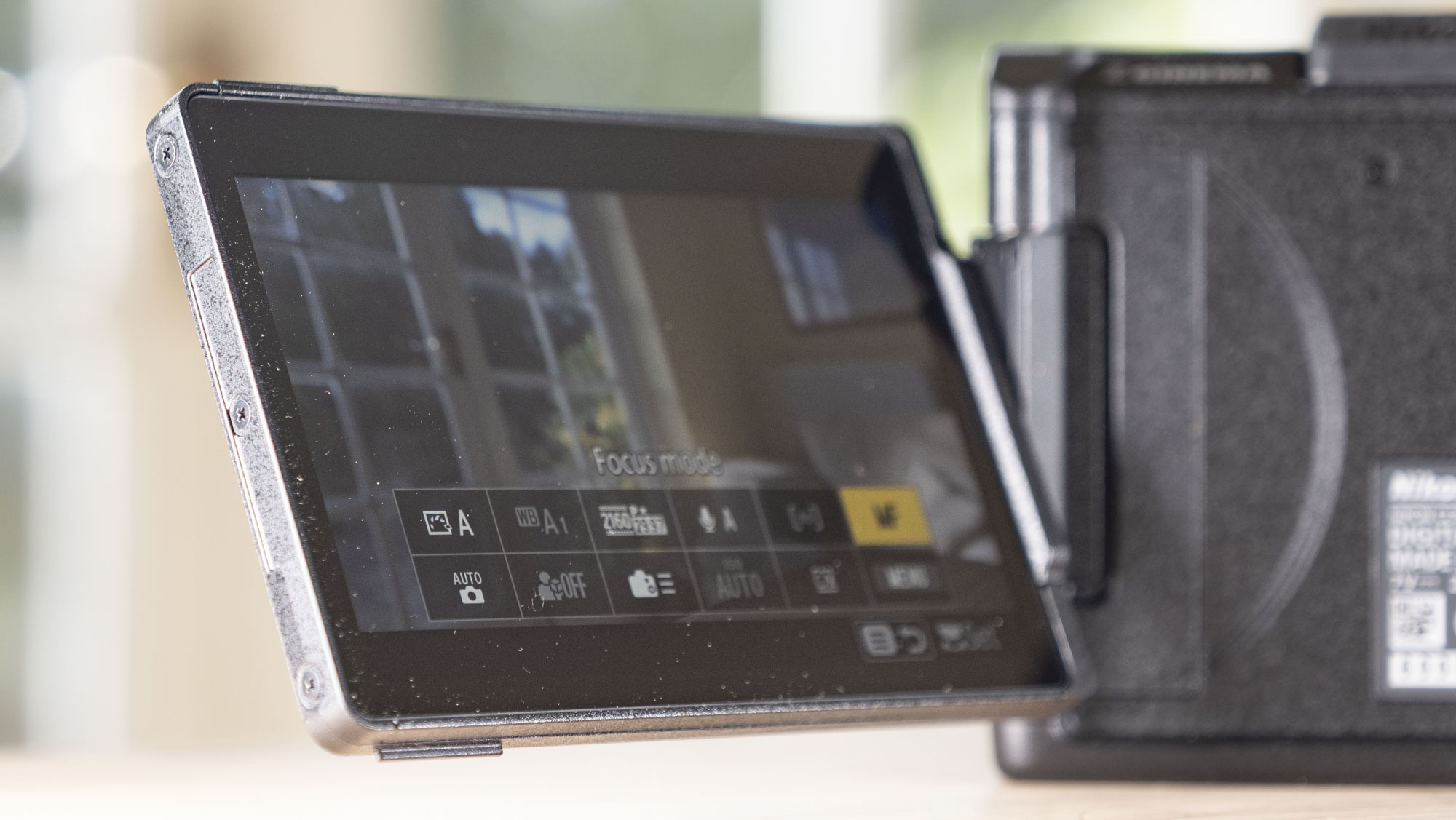 Nikon ZR product photos – camera on a wooden table, screen flipped out
