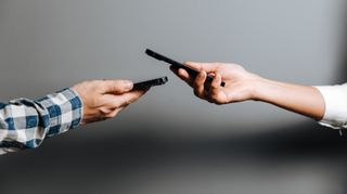 Two people using contactless mobile payments