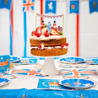Victoria sponge cake on a white cake stand in a jubilee style decorated tea party table