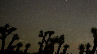 streaks of light race across a starry night sky