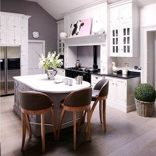 kitchen room with wooden flooring and white cabinets