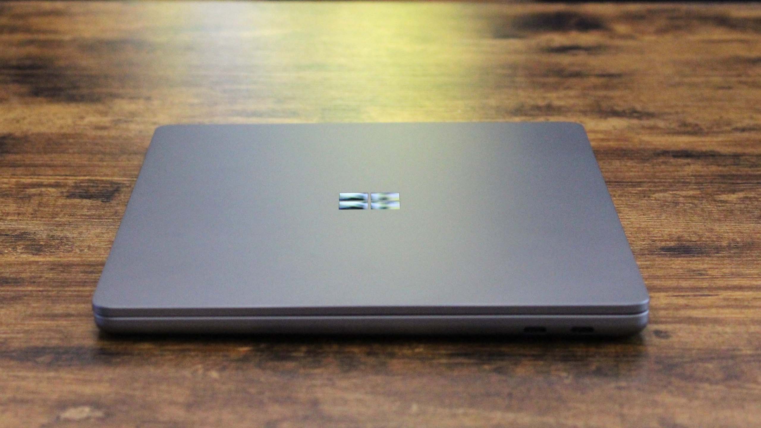 Surface Laptop 13-inch closed on a wooden table, side view.