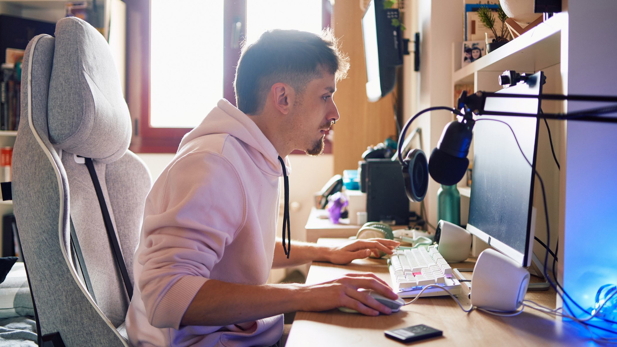 Man leaning forward at gaming /computer desk
