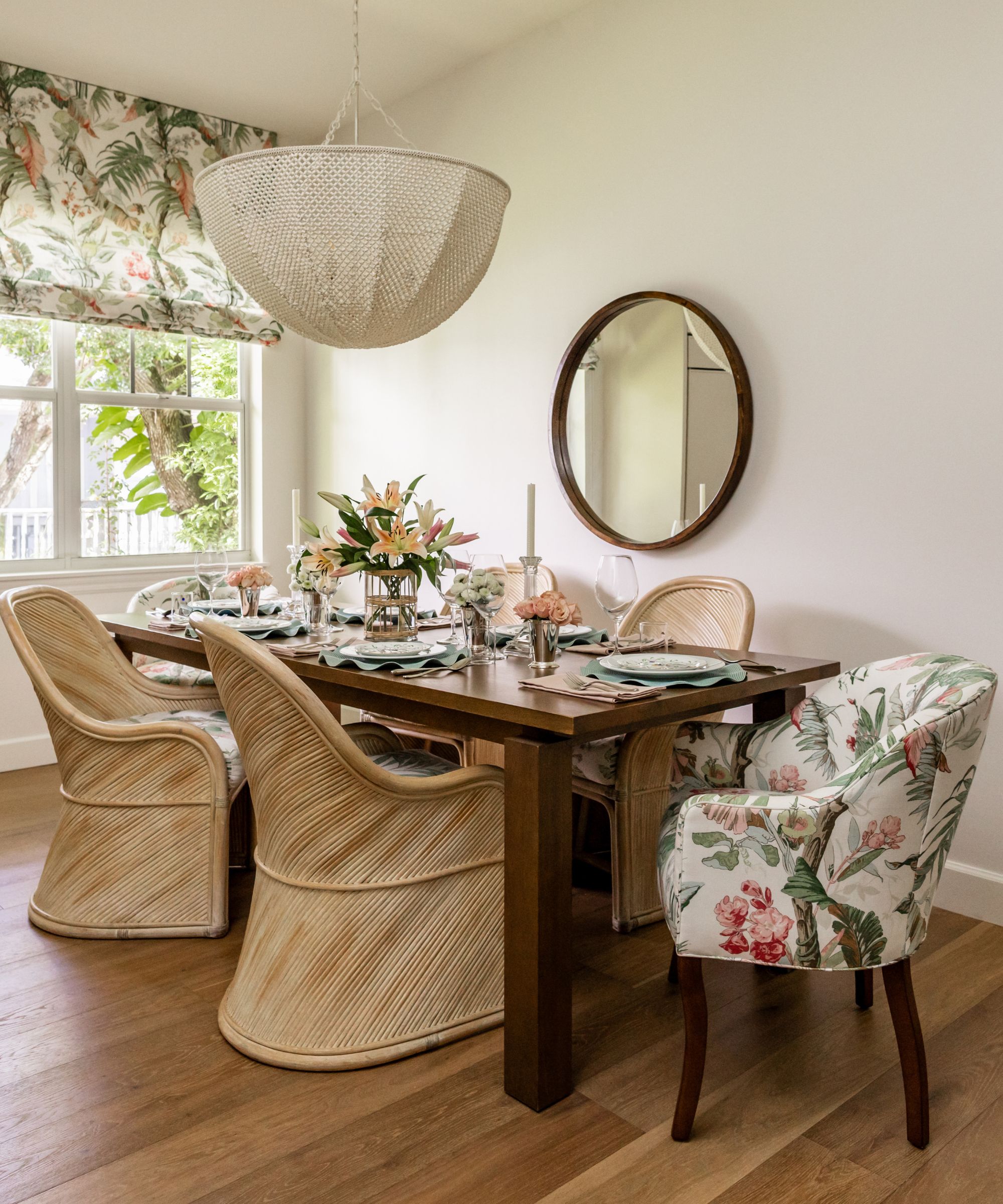 A neutral dining room with a large wooden table, four antique can chairs, and two upholstered chairs at each end