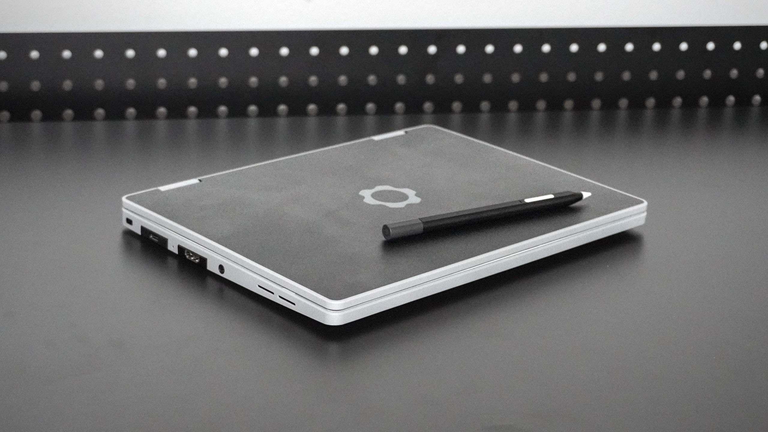 The Framework Laptop 12 with matching stylus lying closed on a desk