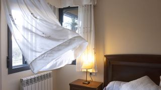 Open window with breeze blowing through in bedroom
