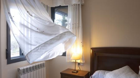 Open window with breeze blowing through in bedroom
