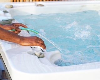 cleaning a hot tub with a hose