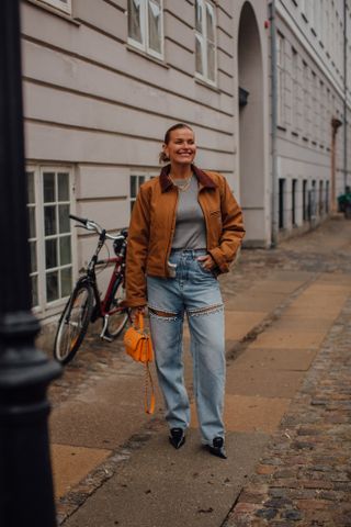 woman wearing barn jacket, barrel jeans, and boots