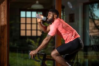 Cyclist rehydrating while training indoors