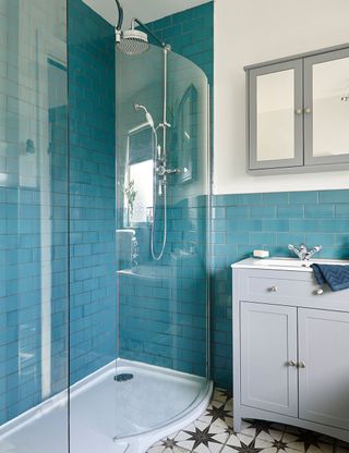 bathroom with blue tiled walls and glass shower room