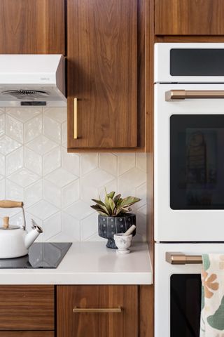 dark kitchen cabinets with white marble worktop and white tile backsplash
