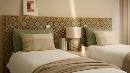 Twin bedroom with patterned headboard, sage pillows, and white bedding with neutral walls.