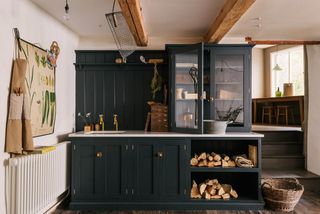 The Cotes Shaker Utility Room with dark cabinets and a glass fronted cabinet. On the bottom right is open shelving with wooden blocks placed inside.