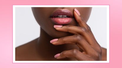 woman touching lips with shiny lip gloss, with a shiny pink lip oil nail-like manicure/ in a pink template